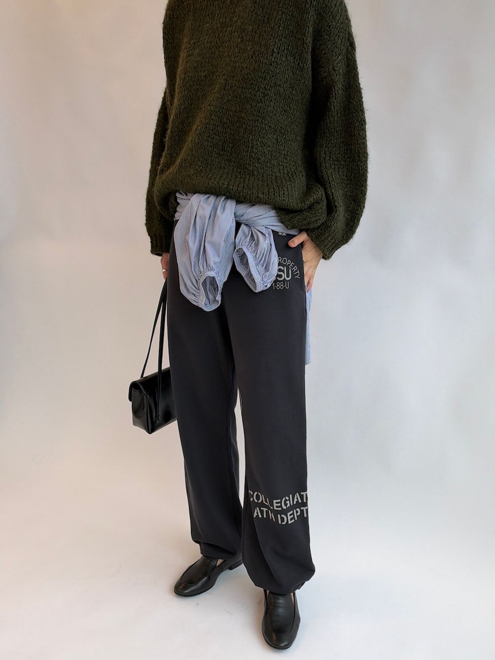 ブルー系のシャツ/ブラウス、グリーン系のニット/セーター、ブラック系のショルダーバッグを着用したレディースの秋コーディネートの4枚目の写真