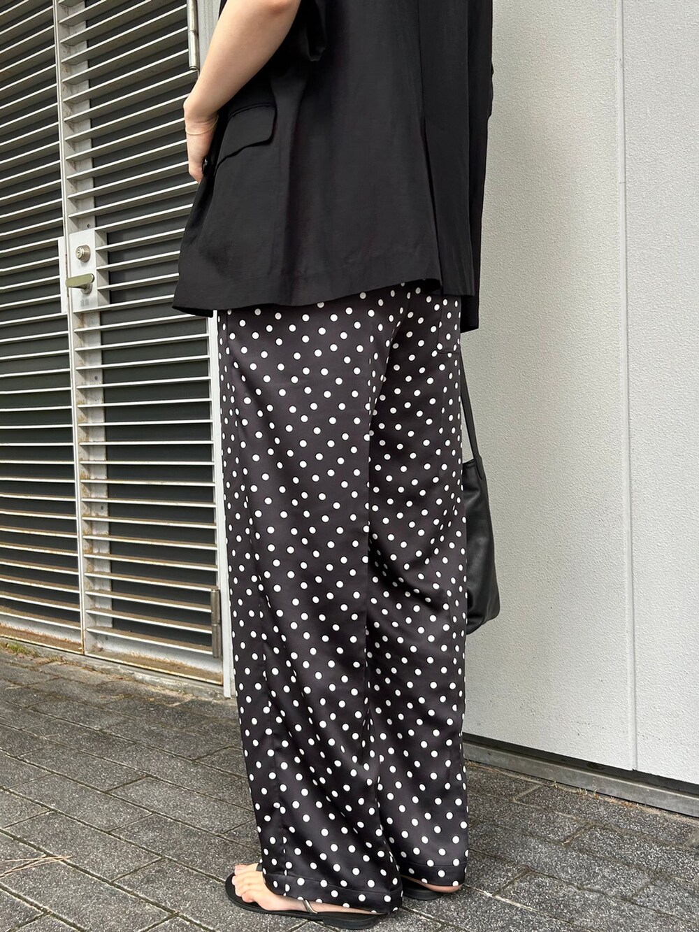 ブラック系のその他アウター、ブラック系のその他パンツ、ブラック系のショルダーバッグを着用したレディースの夏コーディネートの5枚目の写真