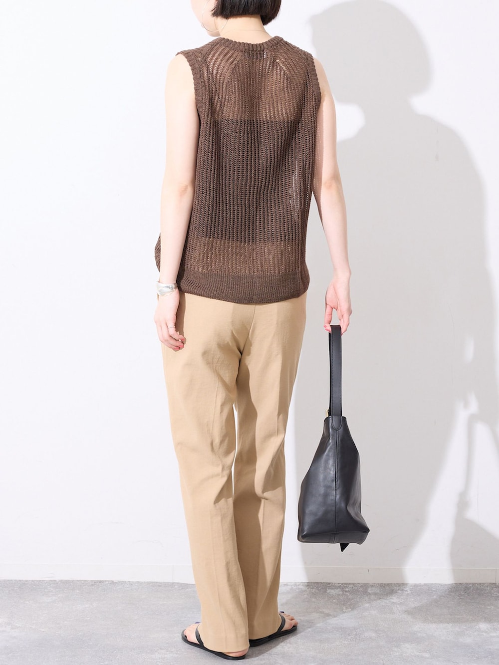 ベージュ系のその他パンツ、ブラウン系のニット/セーター、ブラック系のサンダルを着用したレディースの春コーディネートの5枚目の写真