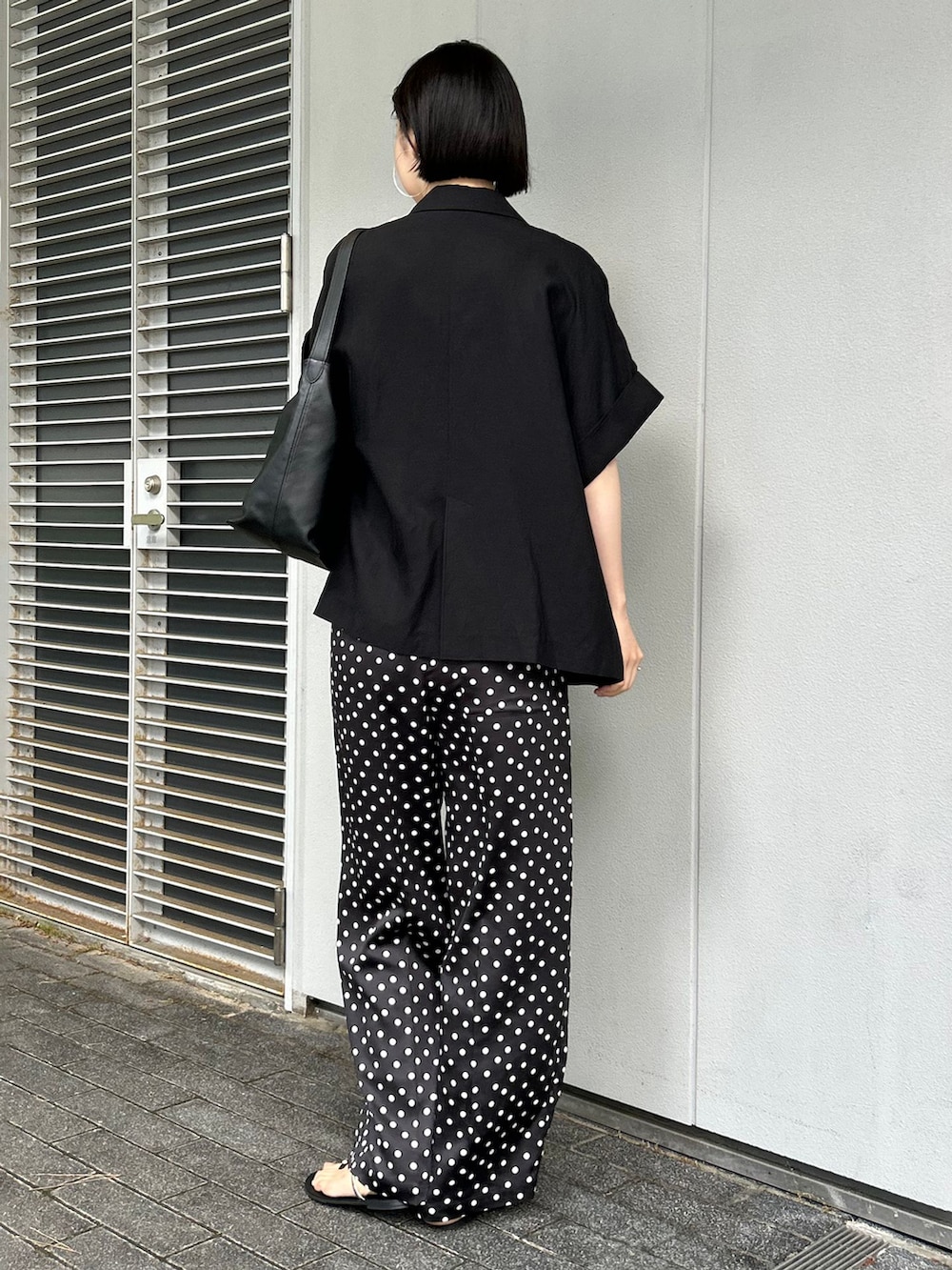 ブラック系のその他アウター、ブラック系のその他パンツ、ブラック系のショルダーバッグを着用したレディースの夏コーディネートの3枚目の写真