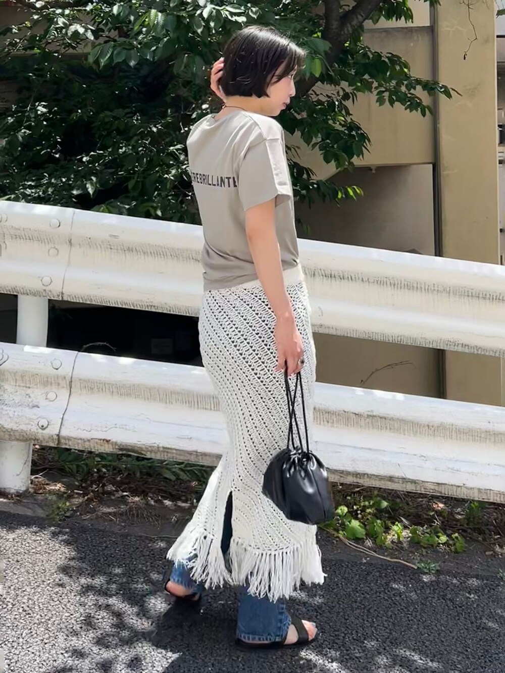 ブルー系のデニムパンツ、ホワイト系のスカート、グリーン系のTシャツ/カットソーを着用したレディースの春コーディネートの2枚目の写真