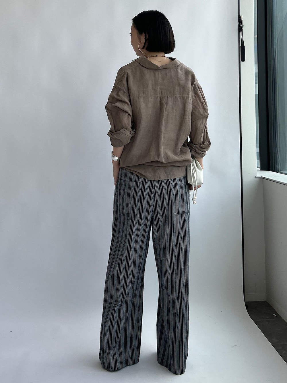 ブラック系のその他パンツ、ベージュ系のシャツ/ブラウス、ホワイト系のタンクトップを着用したレディースの夏コーディネートの4枚目の写真