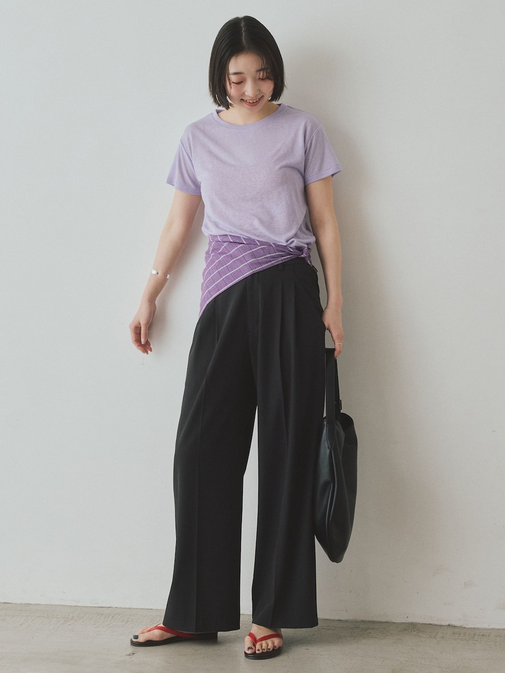 ブラック系のスラックス、パープル系のTシャツ/カットソー、ブラック系のトートバッグを着用したレディースの夏コーディネートの2枚目の写真