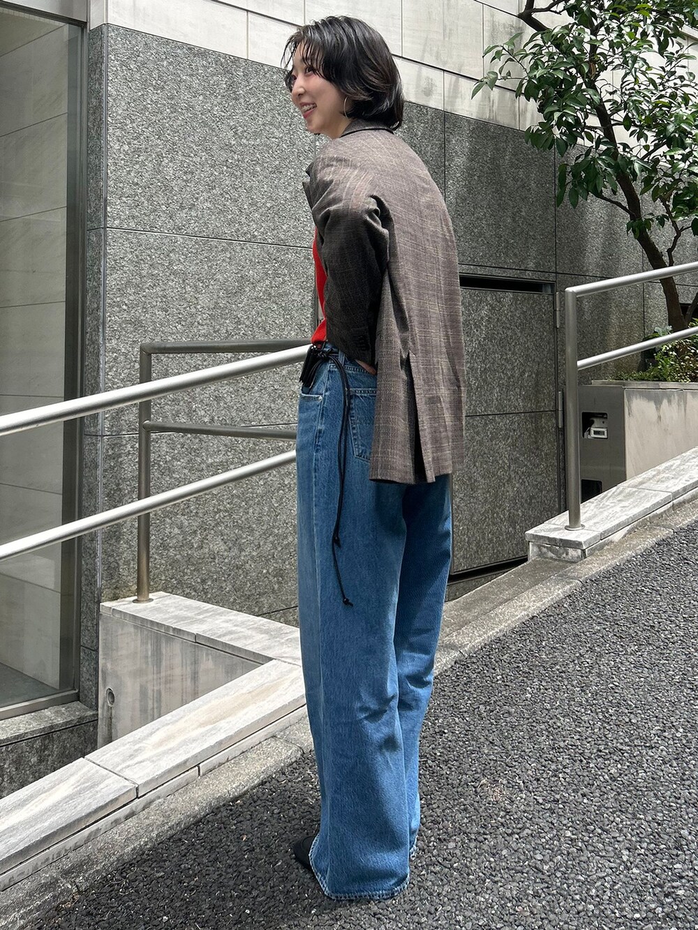 ブラウン系のテーラードジャケット、ブルー系のデニムパンツ、レッド系のTシャツ/カットソーを着用したレディースの夏コーディネートの2枚目の写真