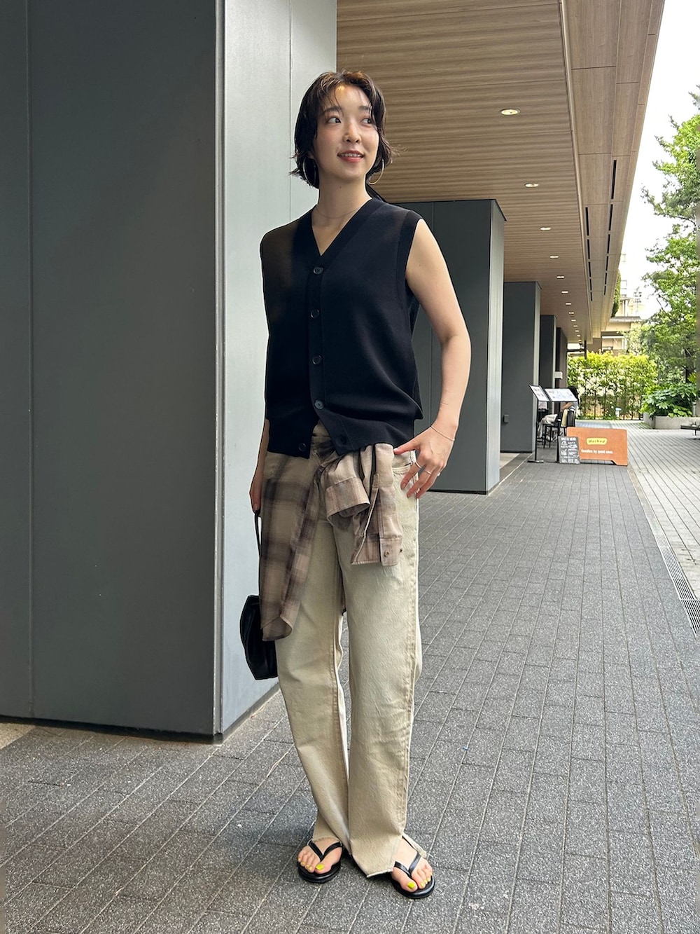 ベージュ系のデニムパンツ、ブラウン系のシャツ/ブラウス、ブラック系のベストを着用したレディースの夏コーディネートの2枚目の写真