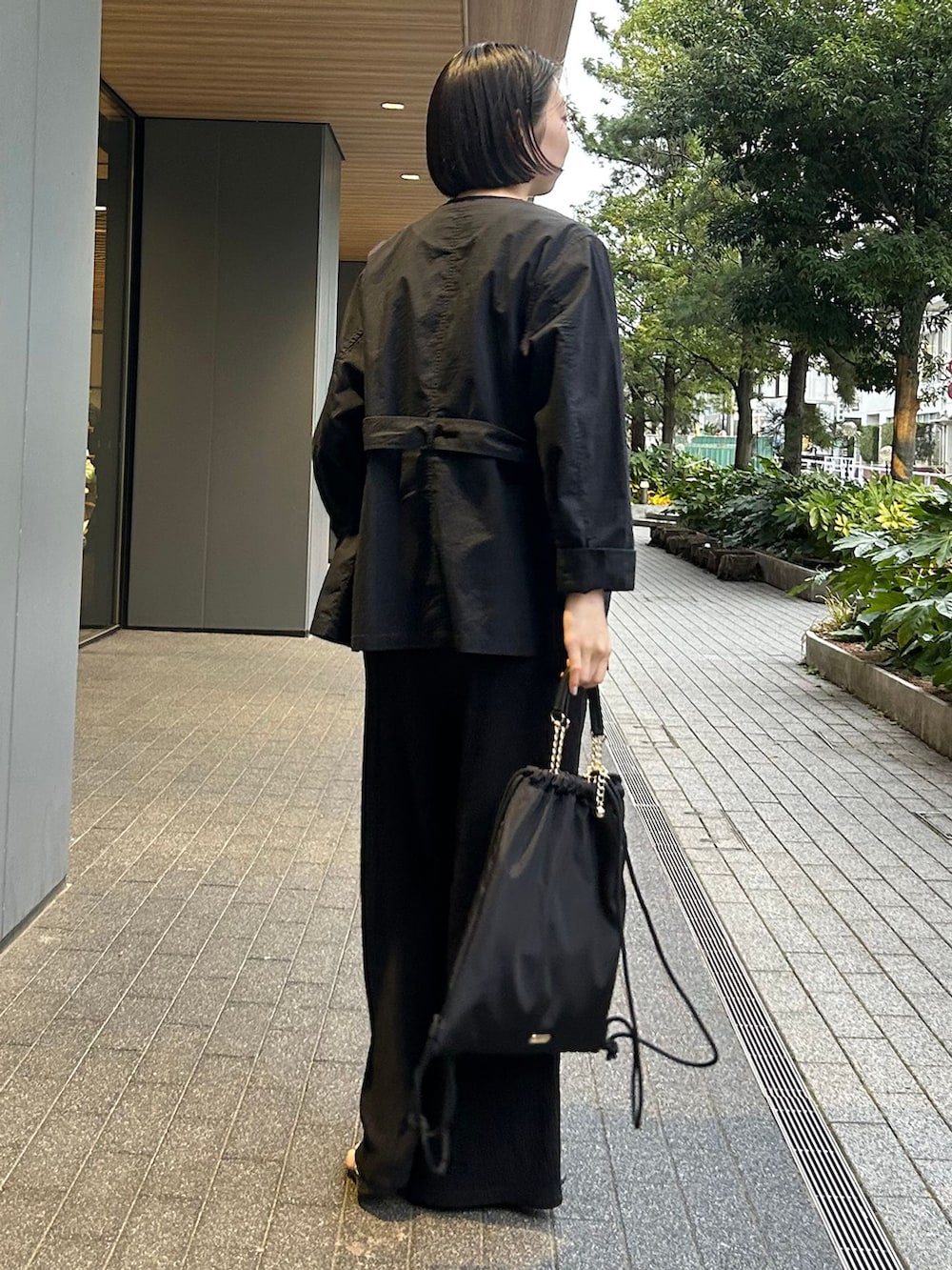 ブラック系のその他アウター、ブラック系のその他パンツ、ブラック系のバックパック/リュックを着用したレディースの春コーディネートの4枚目の写真
