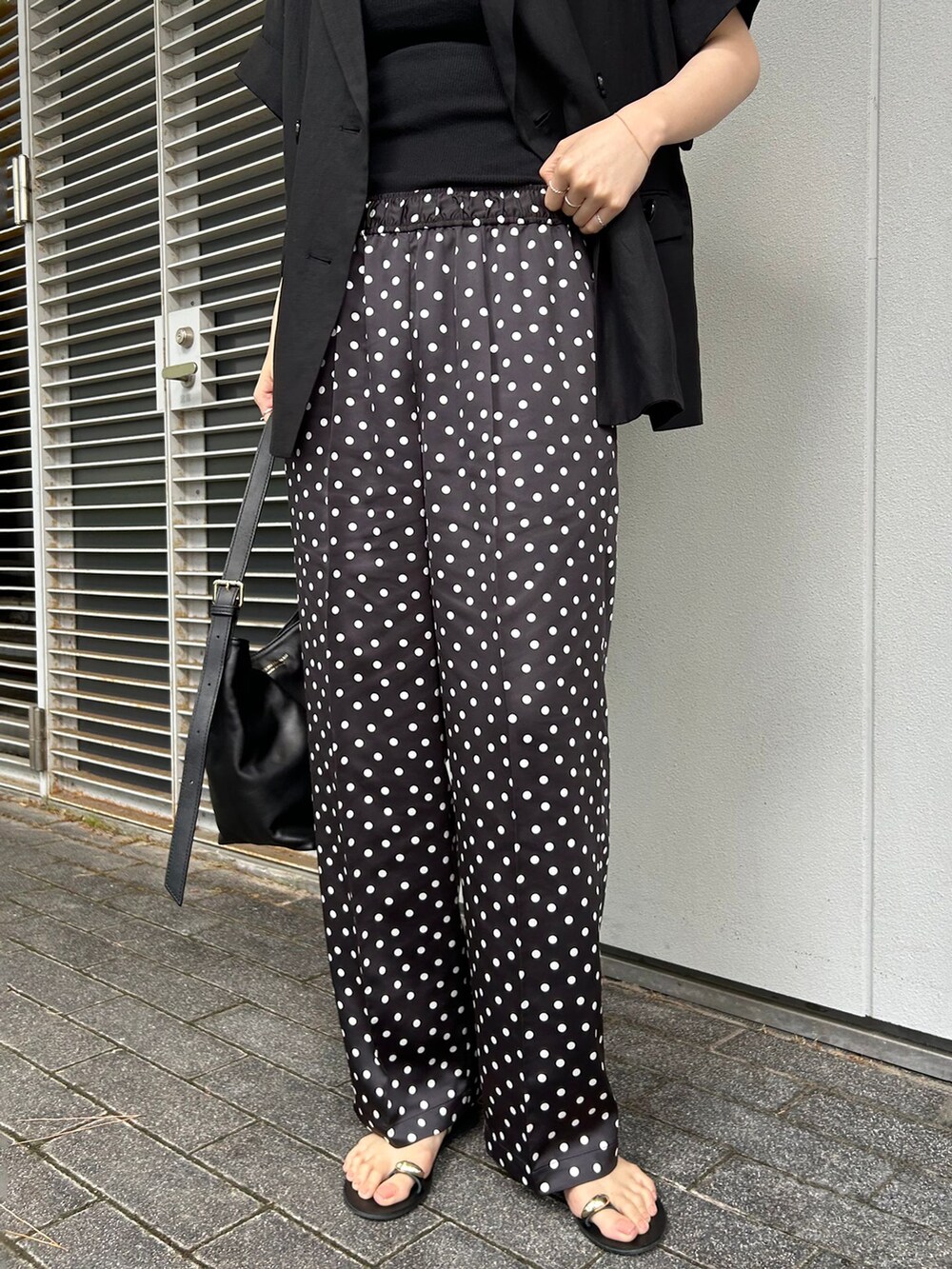 ブラック系のその他アウター、ブラック系のその他パンツ、ブラック系のショルダーバッグを着用したレディースの夏コーディネートの4枚目の写真