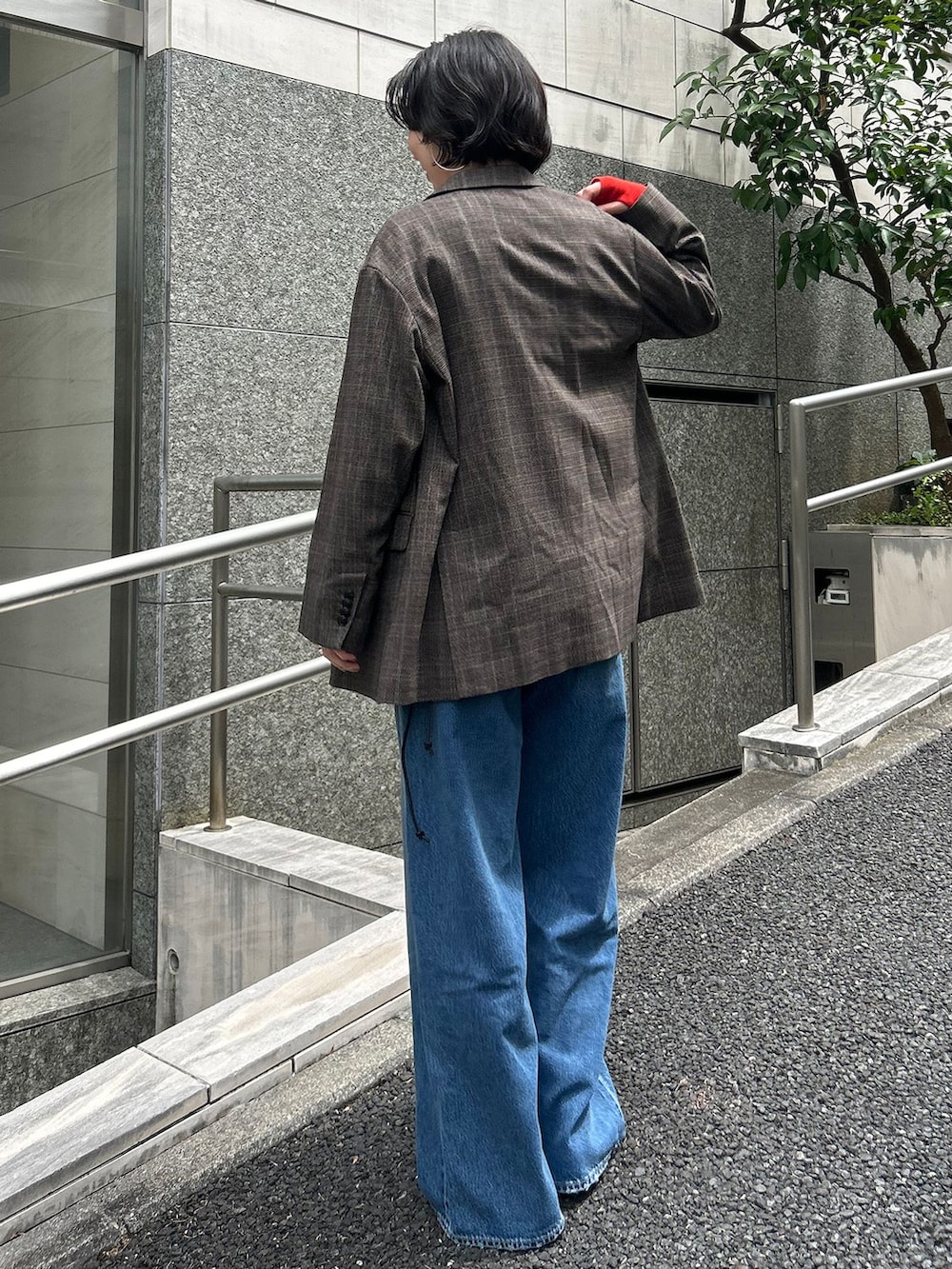 ブラウン系のテーラードジャケット、ブルー系のデニムパンツ、レッド系のTシャツ/カットソーを着用したレディースの夏コーディネートの3枚目の写真