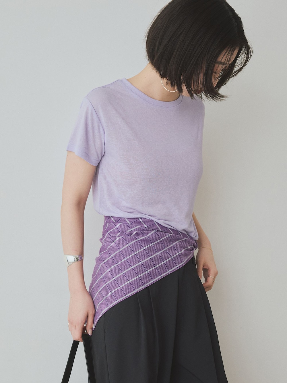 ブラック系のスラックス、パープル系のTシャツ/カットソー、ブラック系のトートバッグを着用したレディースの夏コーディネートの5枚目の写真