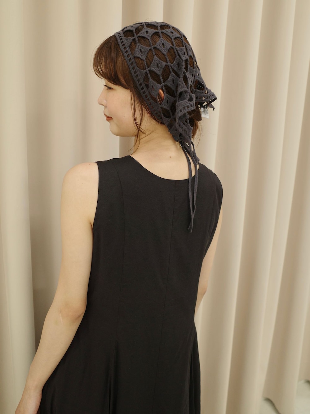 ブラック系のワンピース、ブラウン系のトートバッグ、ブラック系のサンダルを着用したレディースの夏コーディネートの3枚目の写真