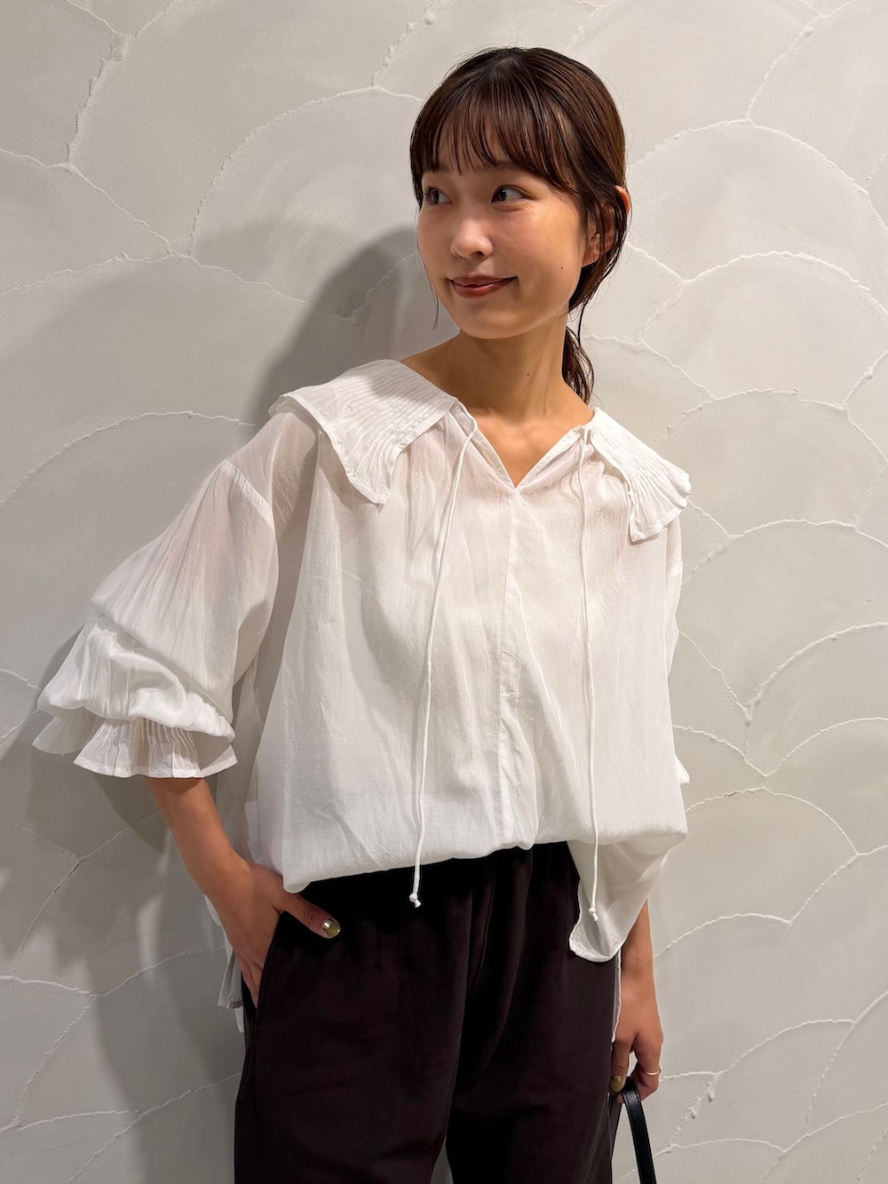 ブラウン系のスウェットパンツ、ホワイト系のシャツ/ブラウス、ブラック系のハンドバッグを着用したレディースの秋コーディネートの4枚目の写真
