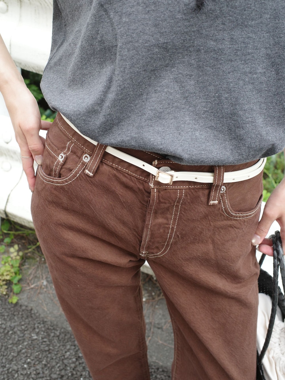ブラウン系のデニムパンツ、グレー系のTシャツ/カットソー、ブラック系のかごバッグを着用したレディースの夏コーディネートの6枚目の写真