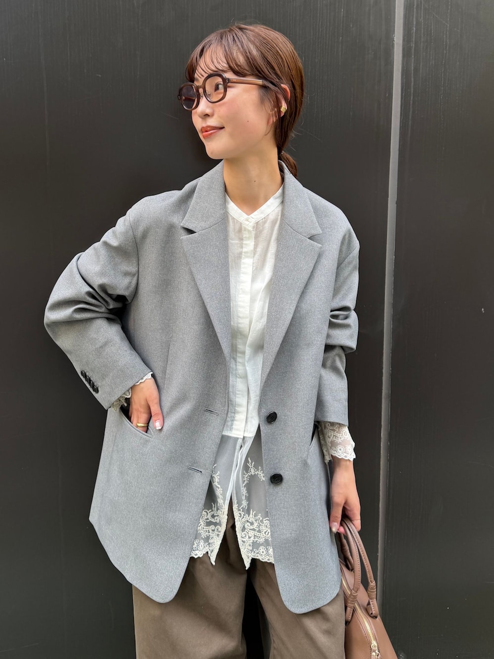 ブラウン系のチノパンツ、ホワイト系のシャツ/ブラウス、ブラウン系のショルダーバッグを着用したレディースの秋コーディネートの4枚目の写真