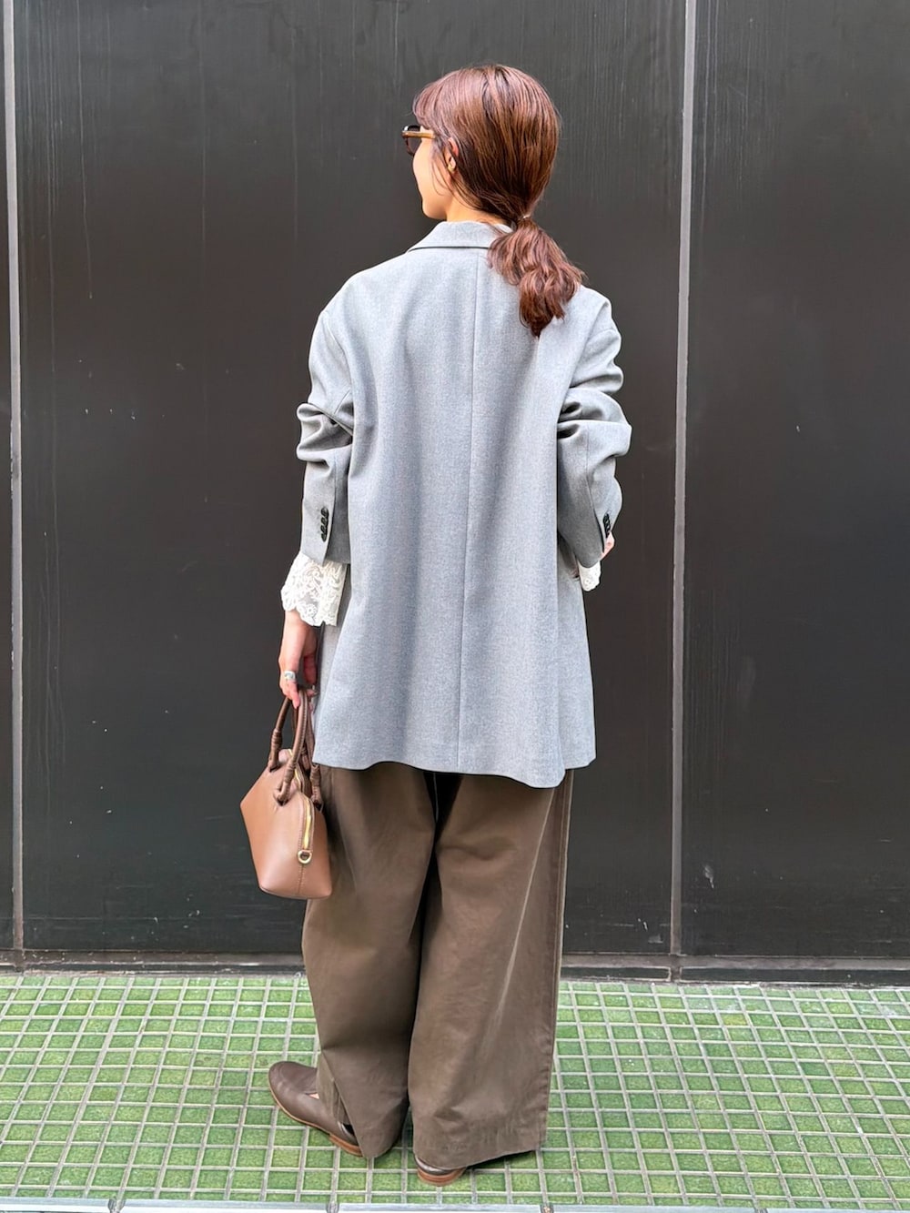 ブラウン系のチノパンツ、ホワイト系のシャツ/ブラウス、ブラウン系のショルダーバッグを着用したレディースの秋コーディネートの3枚目の写真