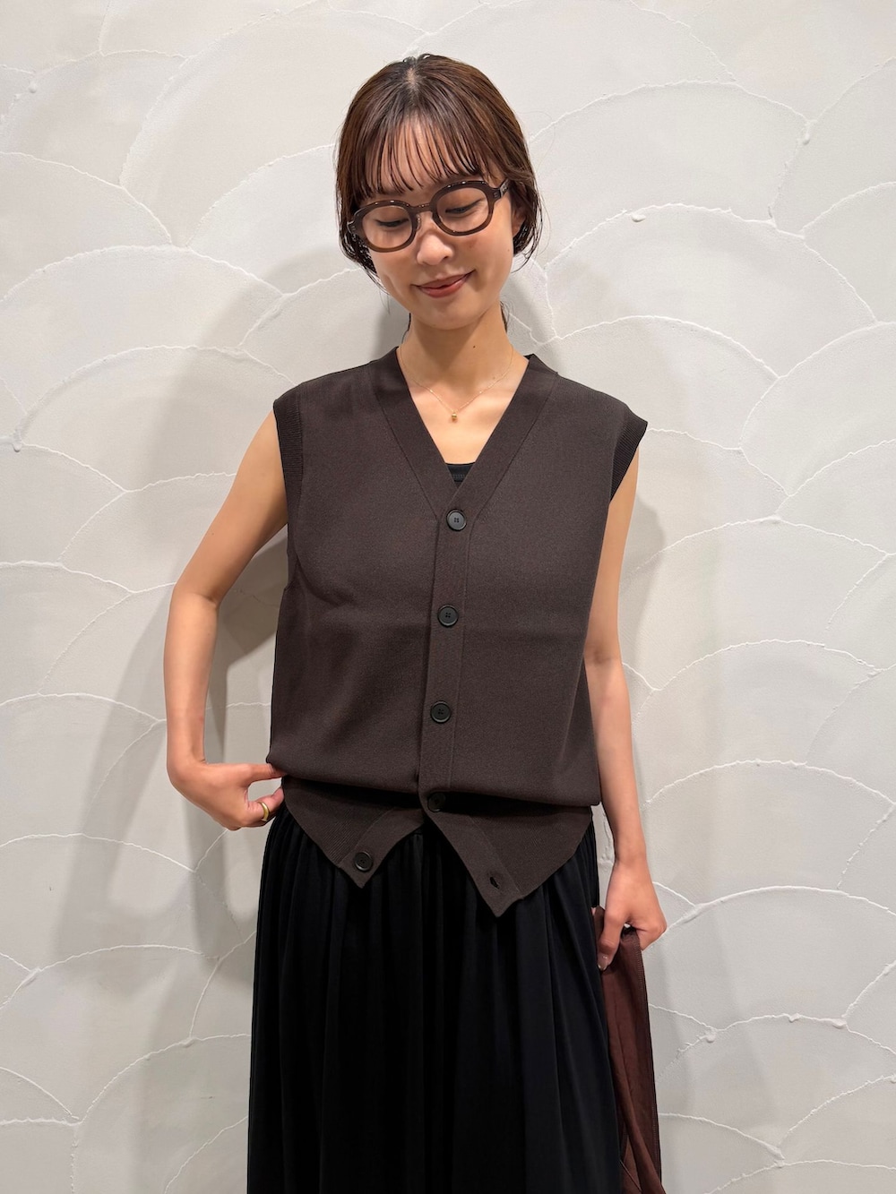 ブラック系のワンピース、ブラウン系のベスト、ブラウン系のトートバッグを着用したレディースの夏コーディネートの5枚目の写真