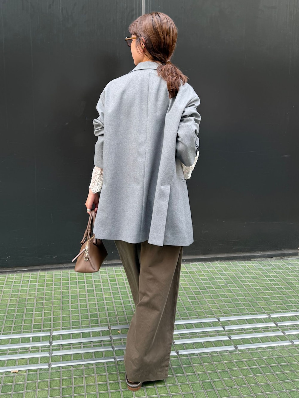 ブラウン系のチノパンツ、ホワイト系のシャツ/ブラウス、ブラウン系のショルダーバッグを着用したレディースの秋コーディネートの7枚目の写真