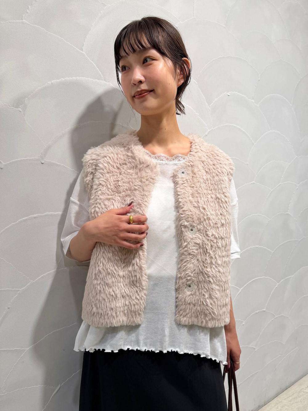 ホワイト系のTシャツ/カットソー、ホワイト系のベスト、グリーン系のローファーを着用したレディースの夏コーディネートの4枚目の写真