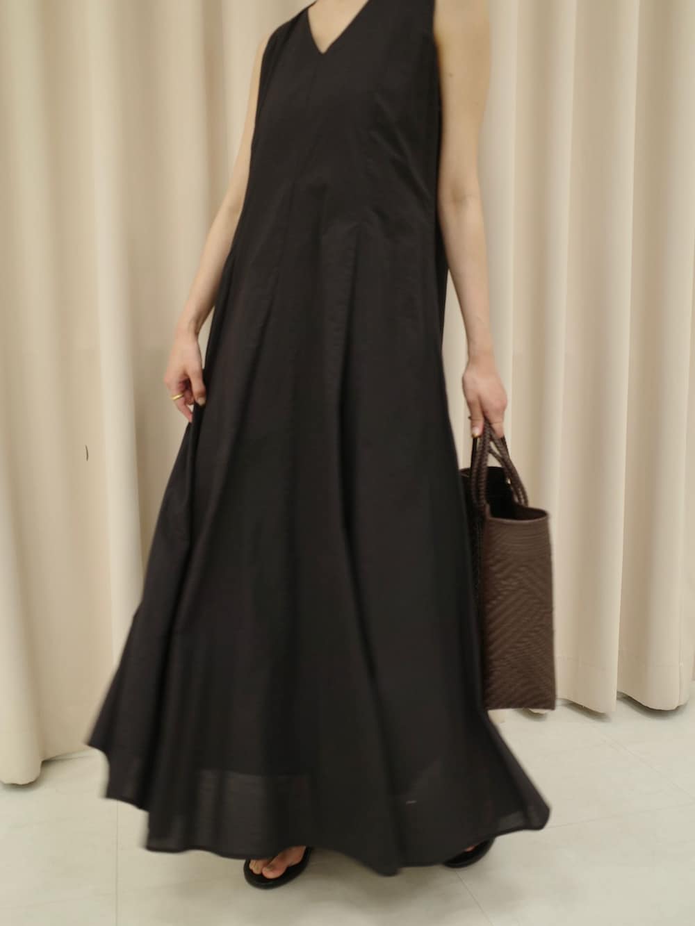 ブラック系のワンピース、ブラウン系のトートバッグ、ブラック系のサンダルを着用したレディースの夏コーディネートの4枚目の写真