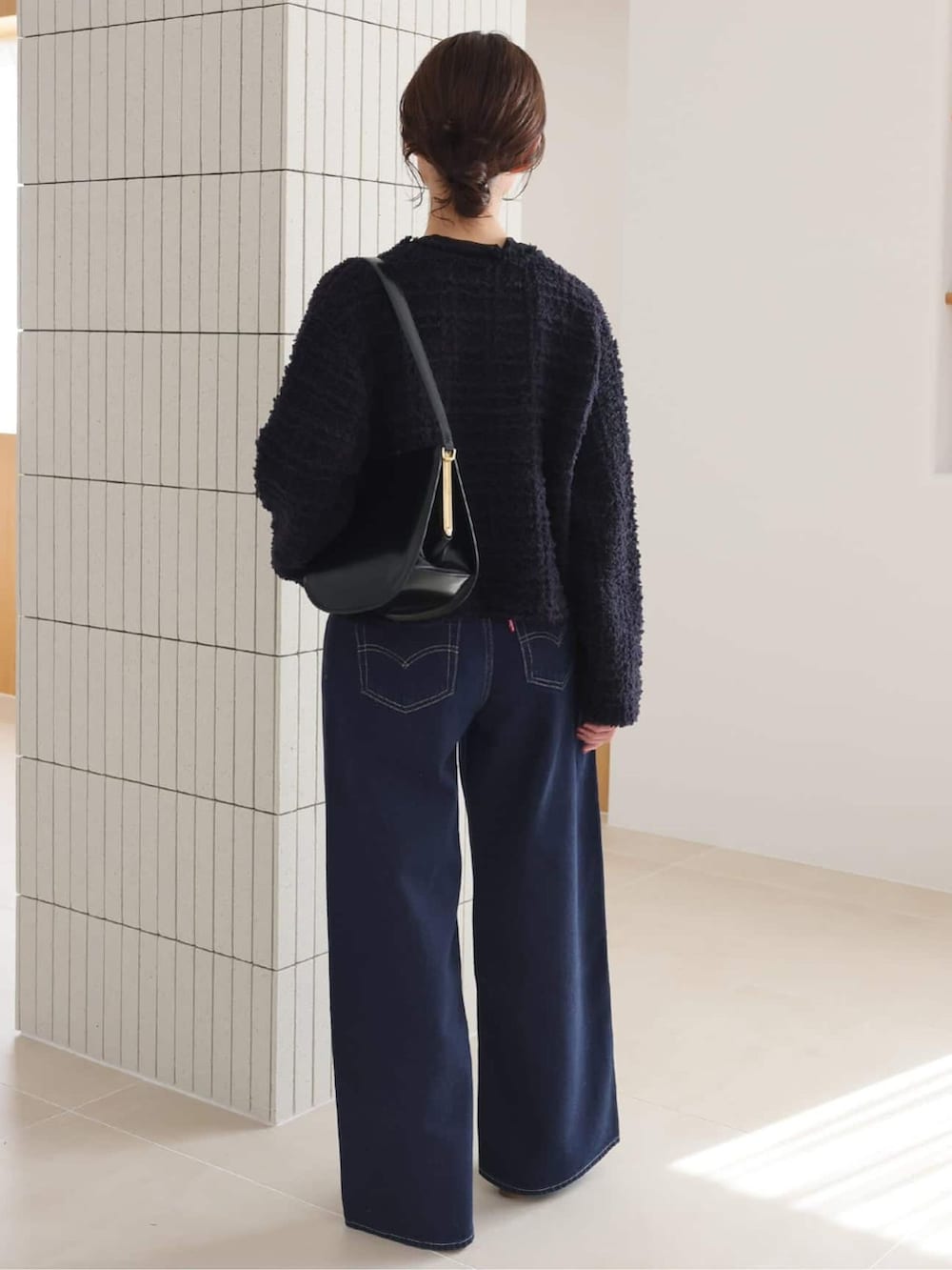 ブルー系のデニムパンツ、ブラック系のTシャツ/カットソー、ブルー系のカーディガン/ボレロを着用したレディースの秋コーディネートの3枚目の写真