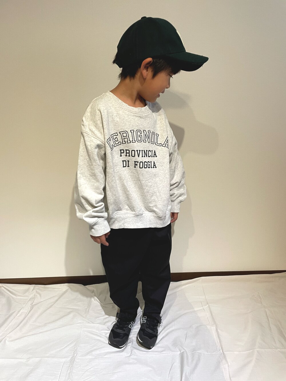 ホワイト系のスウェット、ブラック系のチノパンツ、ブラック系のスニーカーを着用したキッズの秋コーディネートの2枚目の写真