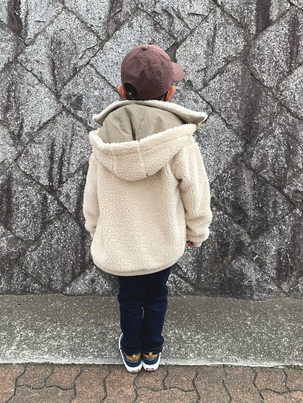 ホワイト系のニット/セーター、ブルー系のデニムパンツ、ブルー系のスニーカーを着用したキッズの冬コーディネートの2枚目の写真