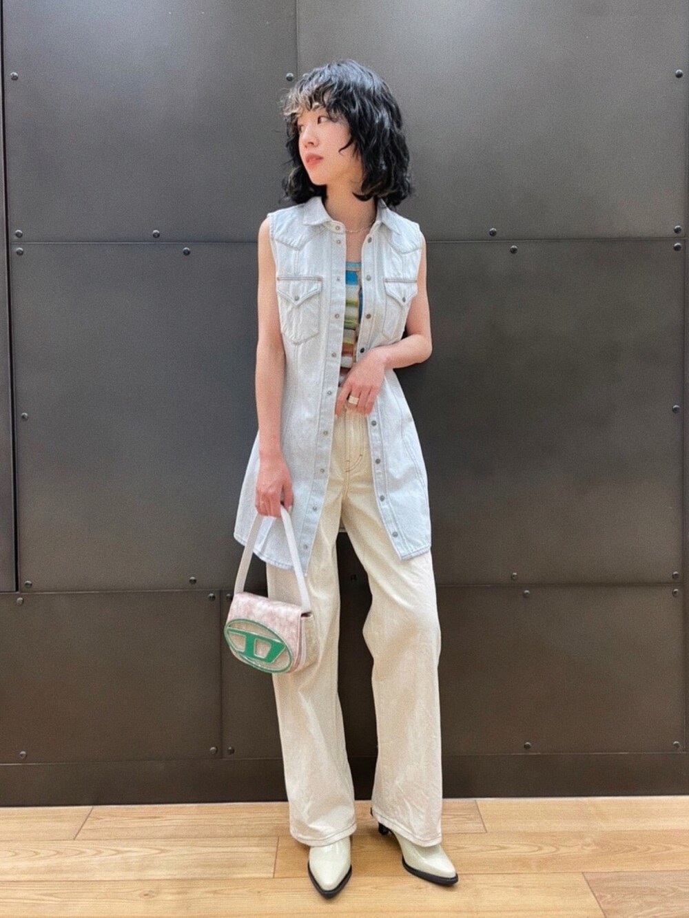 グリーン系のショルダーバッグ、ホワイト系のデニムパンツ、ブルー系のワンピースを着用したレディースの春コーディネートの2枚目の写真