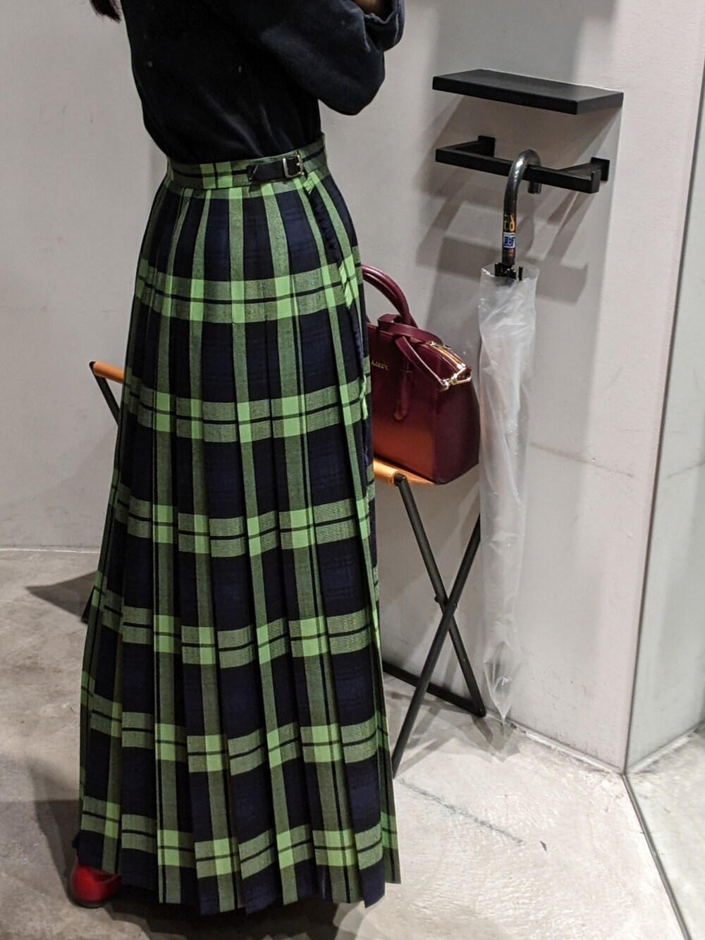 グリーン系のスカートを着用したレディースの秋コーディネートの2枚目の写真