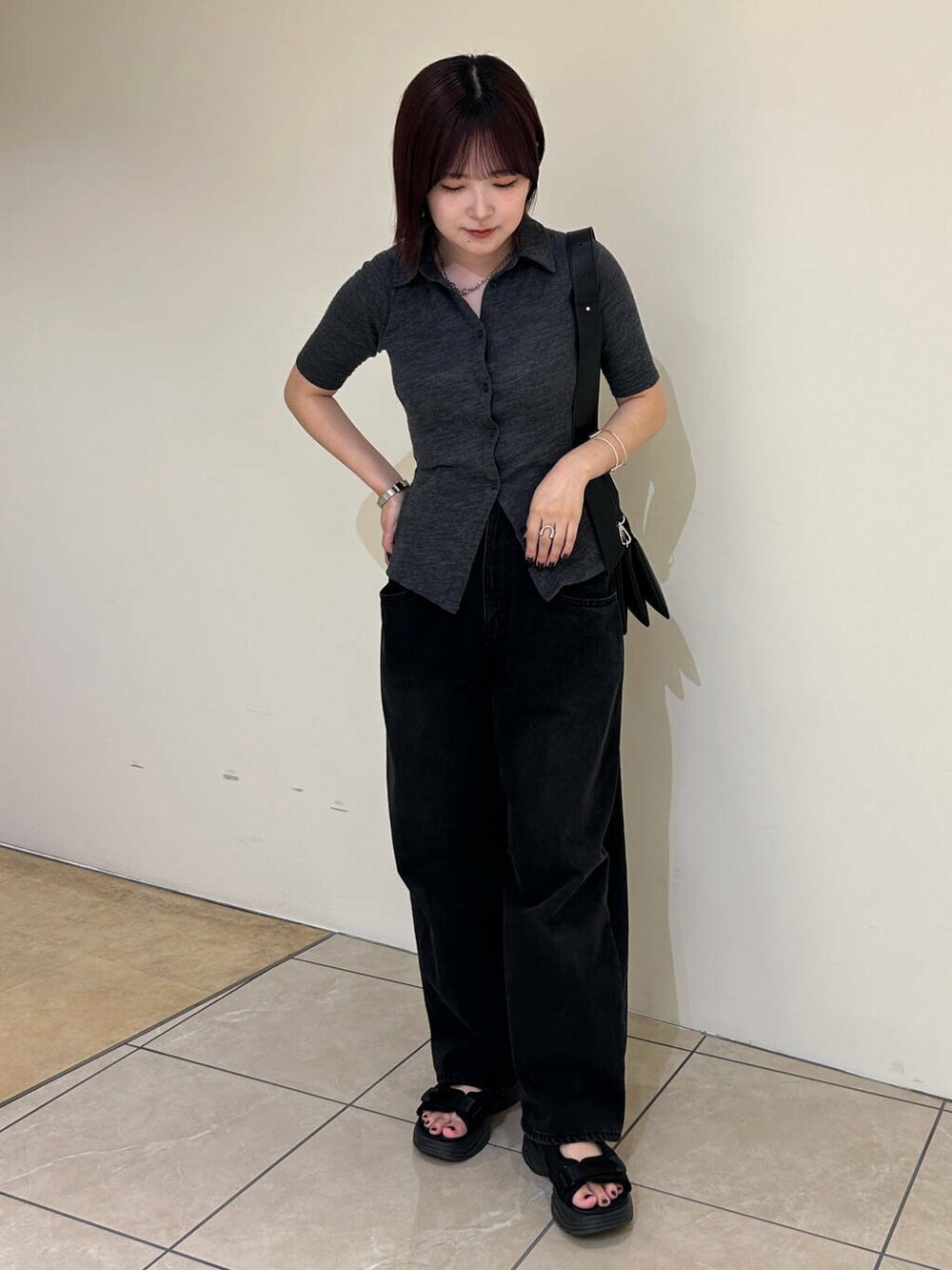 ブラック系のデニムパンツ、ブラック系のショルダーバッグ、ブラック系のサンダルを着用したレディースの夏コーディネートの3枚目の写真