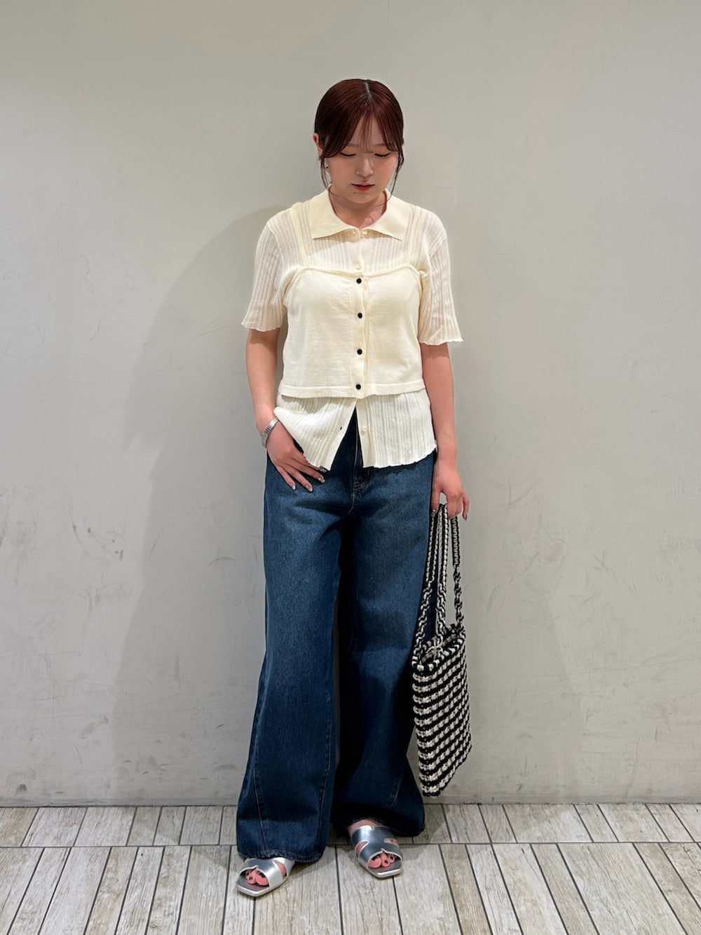 ホワイト系のニット/セーター、ブルー系のデニムパンツ、シルバー系のサンダルを着用したレディースの夏コーディネートの2枚目の写真