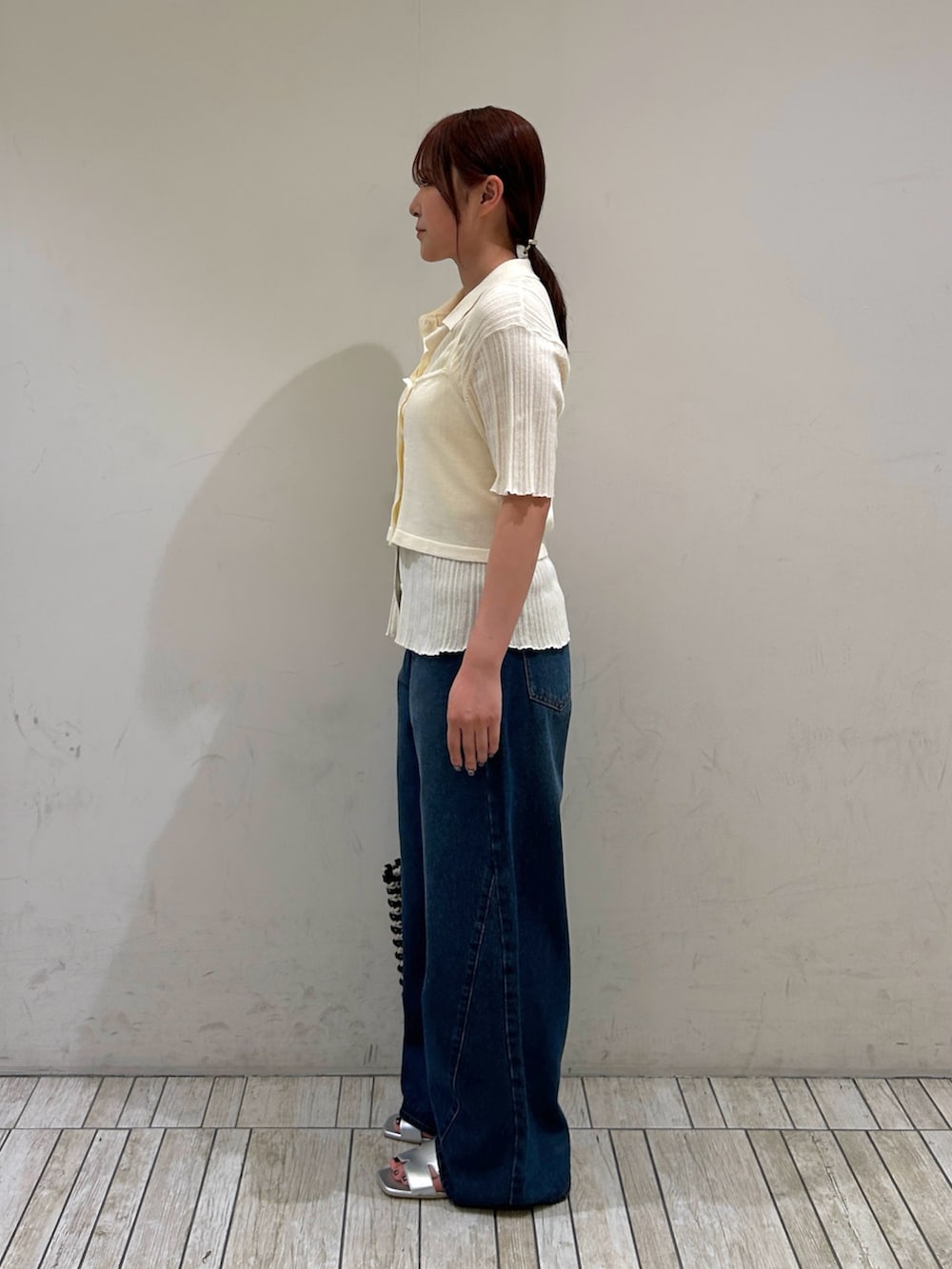 ホワイト系のニット/セーター、ブルー系のデニムパンツ、シルバー系のサンダルを着用したレディースの夏コーディネートの3枚目の写真