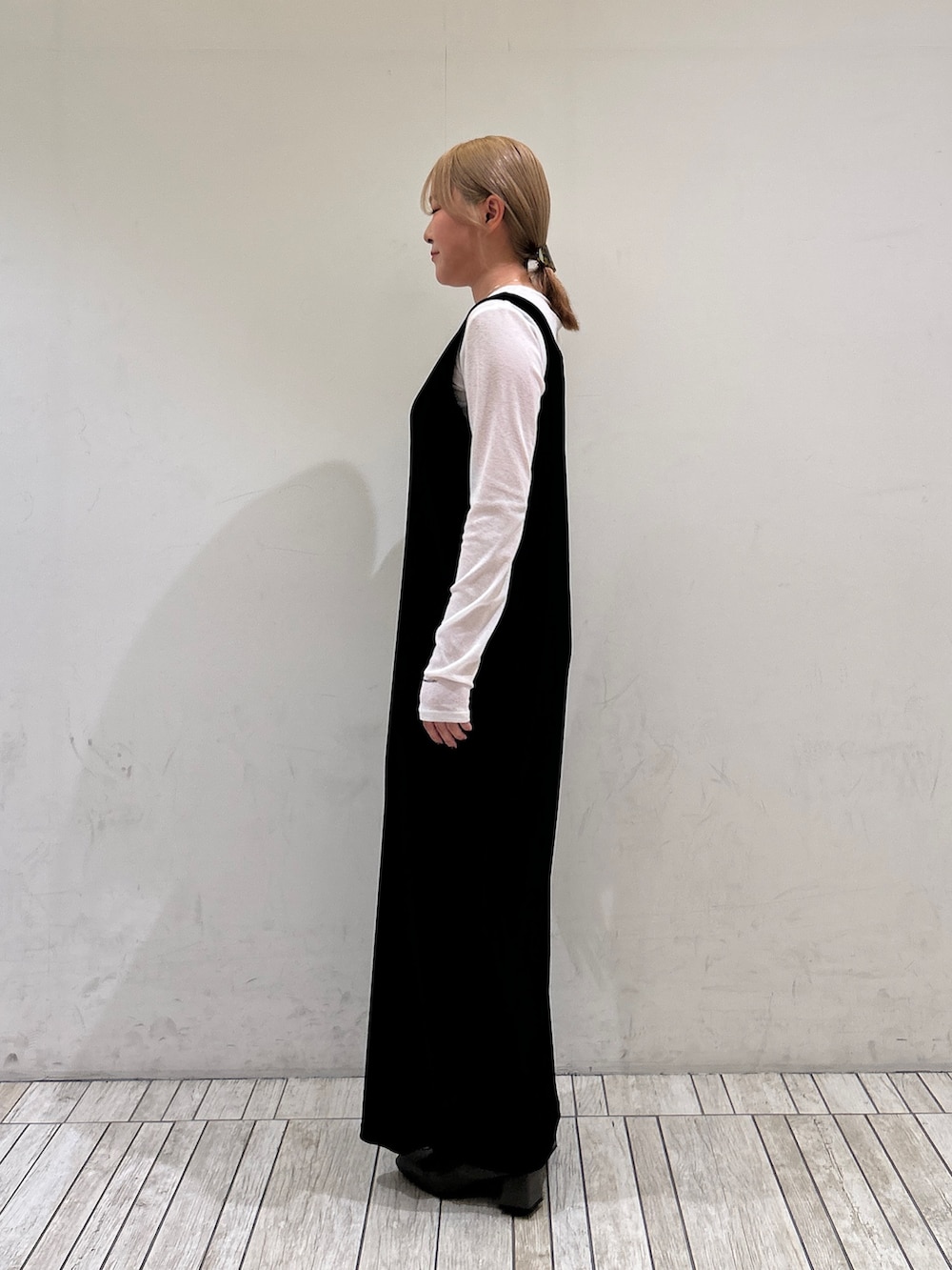 ブラック系のワンピース、ホワイト系のTシャツ/カットソー、グリーン系のパンプスを着用したレディースの春コーディネートの3枚目の写真