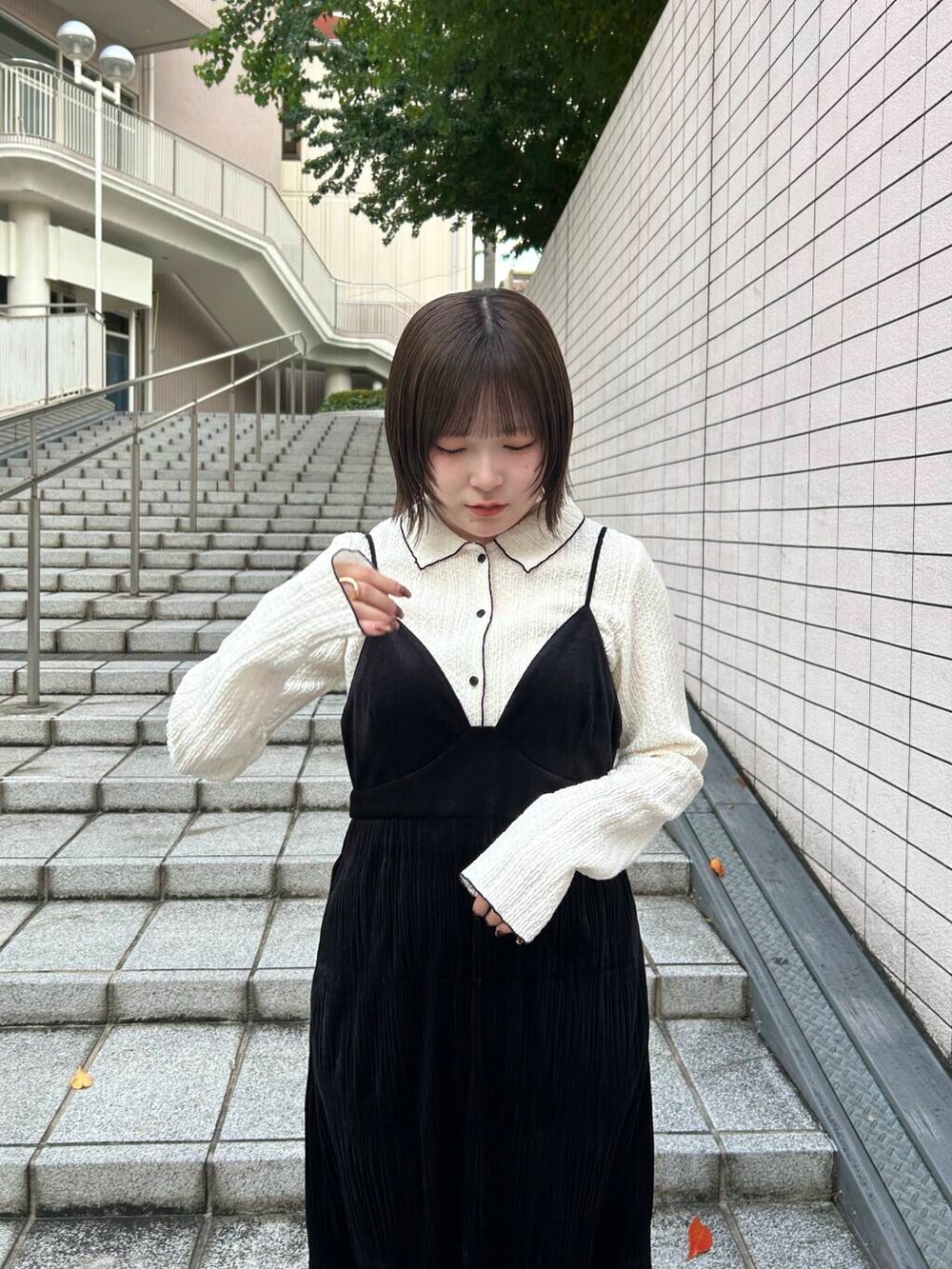 ブラック系のブーツ、ブラック系のワンピース、ホワイト系のシャツ/ブラウスを着用したレディースの冬コーディネートの4枚目の写真