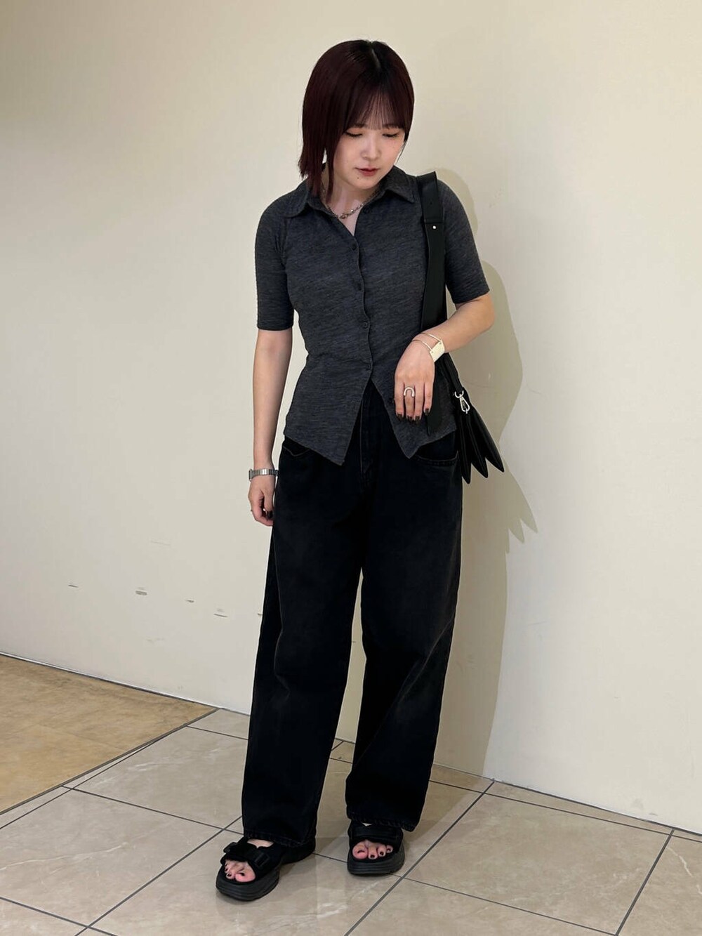 ブラック系のデニムパンツ、ブラック系のショルダーバッグ、ブラック系のサンダルを着用したレディースの夏コーディネートの2枚目の写真