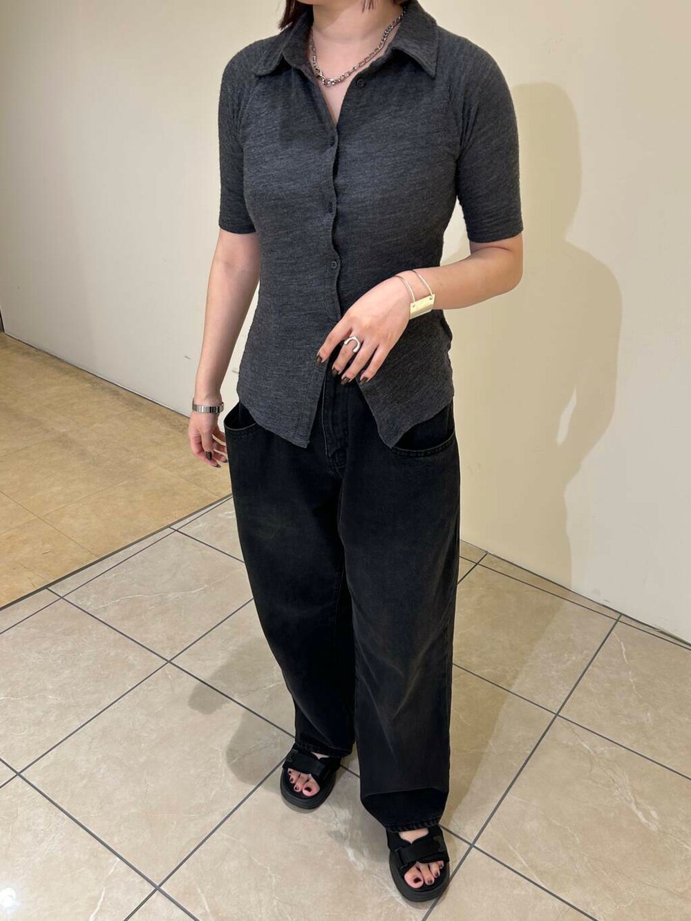 ブラック系のデニムパンツ、ブラック系のショルダーバッグ、ブラック系のサンダルを着用したレディースの夏コーディネートの5枚目の写真