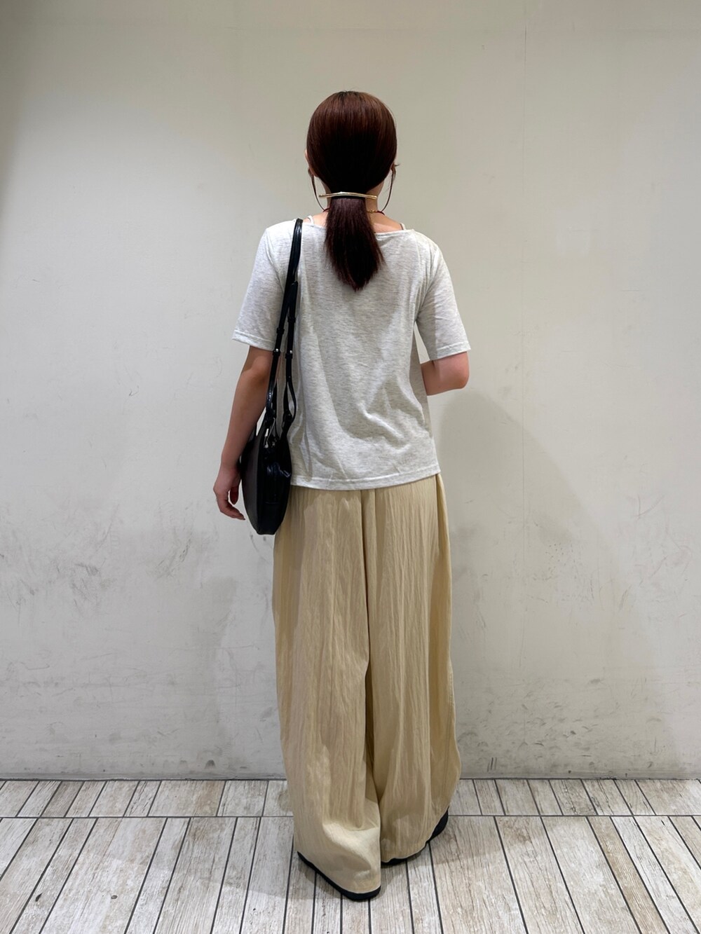 ブラック系のショルダーバッグ、イエロー系のその他パンツ、ベージュ系のTシャツ/カットソーを着用したレディースの夏コーディネートの4枚目の写真