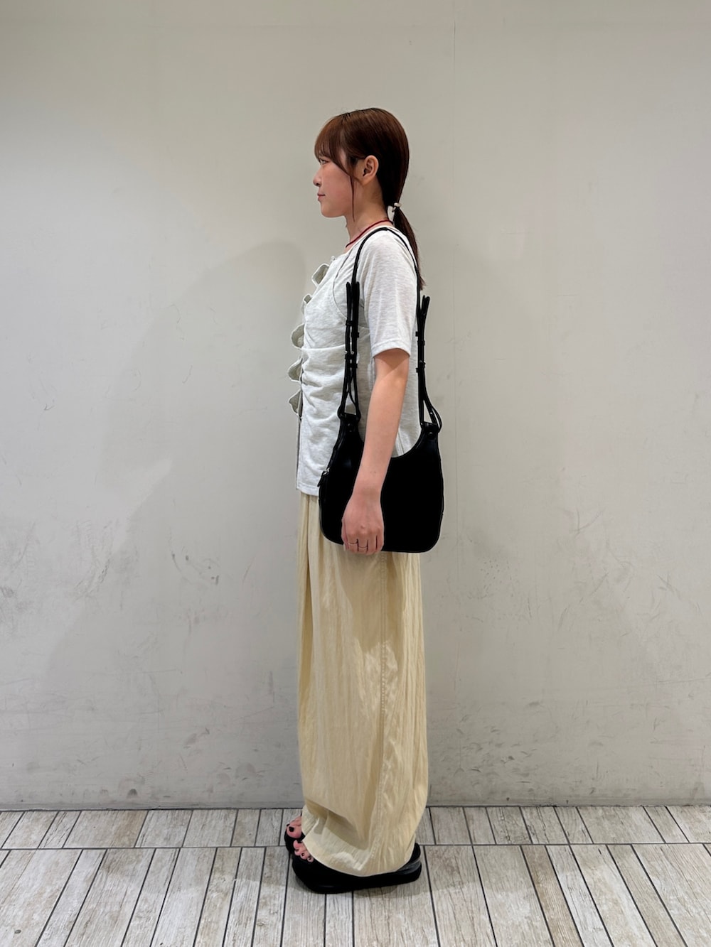 ブラック系のショルダーバッグ、イエロー系のその他パンツ、ベージュ系のTシャツ/カットソーを着用したレディースの夏コーディネートの3枚目の写真