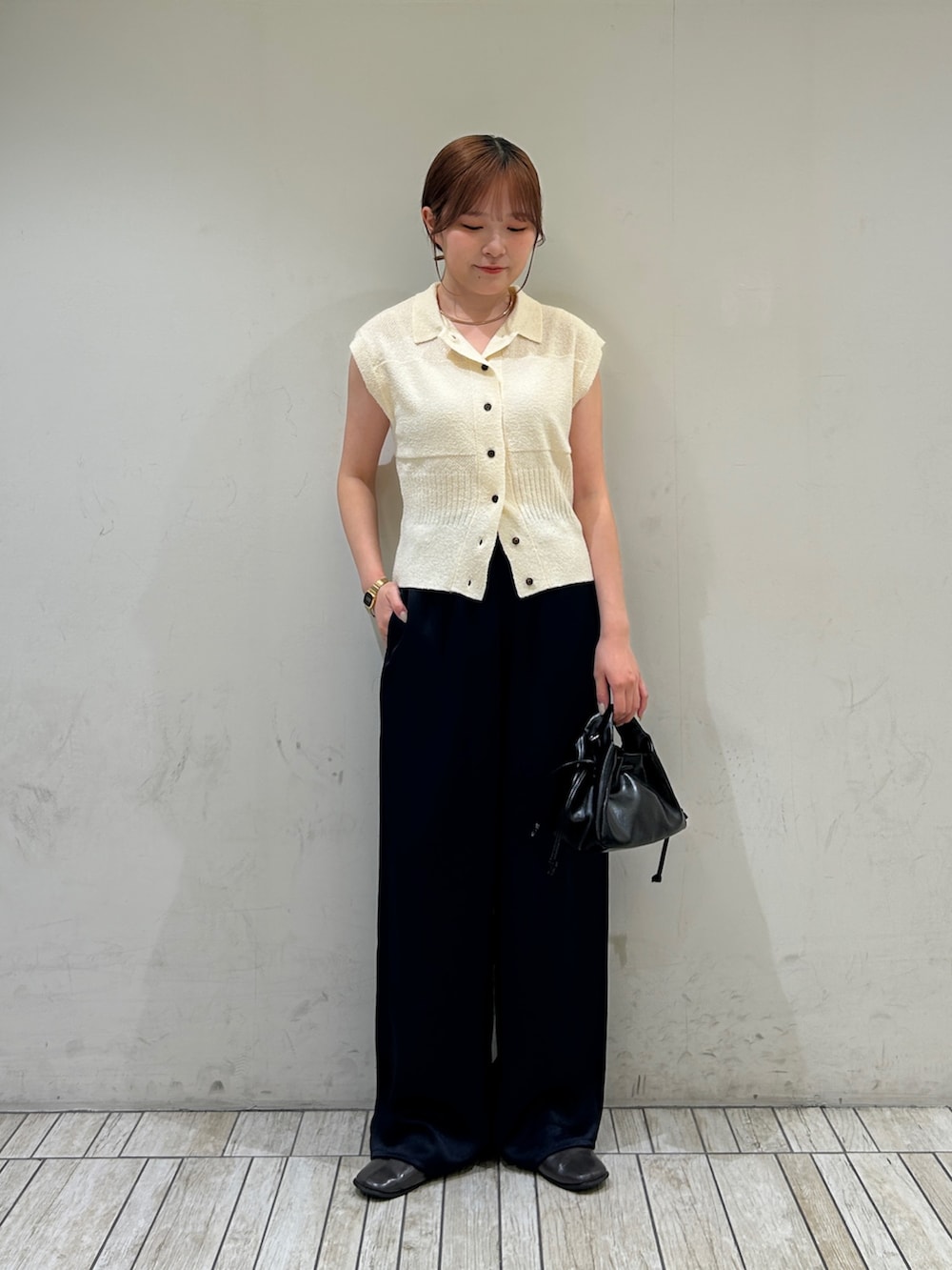 ホワイト系のニット/セーター、ブルー系のその他パンツ、ブラック系のハンドバッグを着用したレディースの夏コーディネートの2枚目の写真