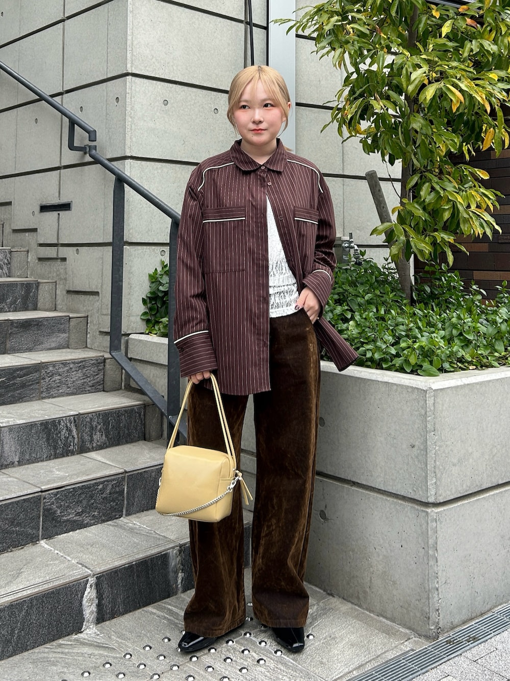 ブラウン系のシャツ/ブラウス、ホワイト系のTシャツ/カットソー、ブラウン系のデニムパンツを着用したレディースの春コーディネートの4枚目の写真