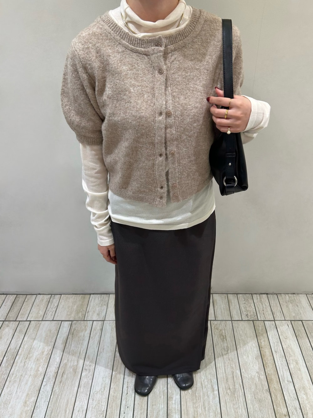 ベージュ系のカーディガン/ボレロ、ブラック系のショルダーバッグ、ブラウン系のスカートを着用したレディースの秋コーディネートの6枚目の写真