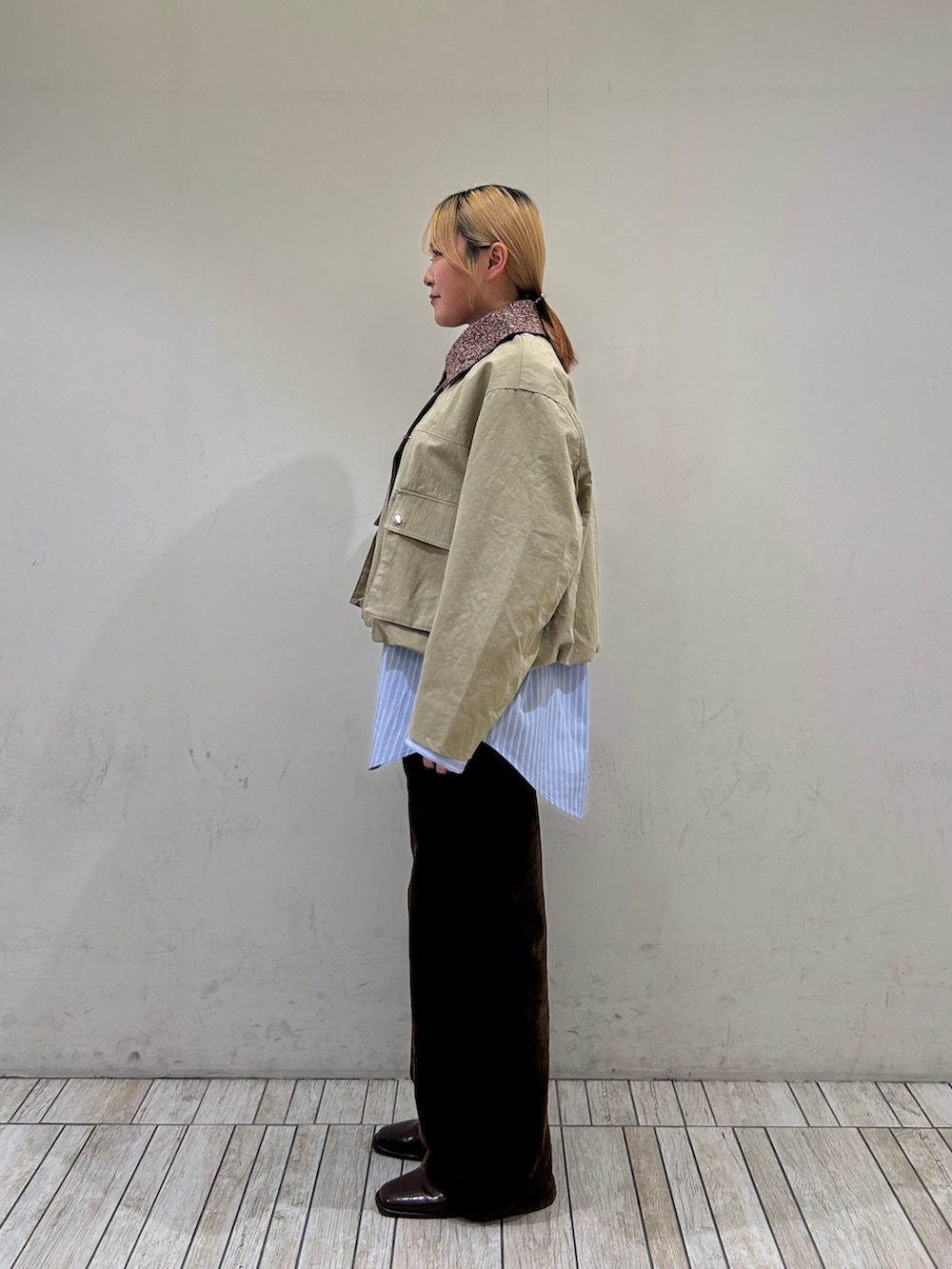 ベージュ系のブルゾン、ブルー系のシャツ/ブラウス、ブラウン系のデニムパンツを着用したレディースの冬コーディネートの3枚目の写真