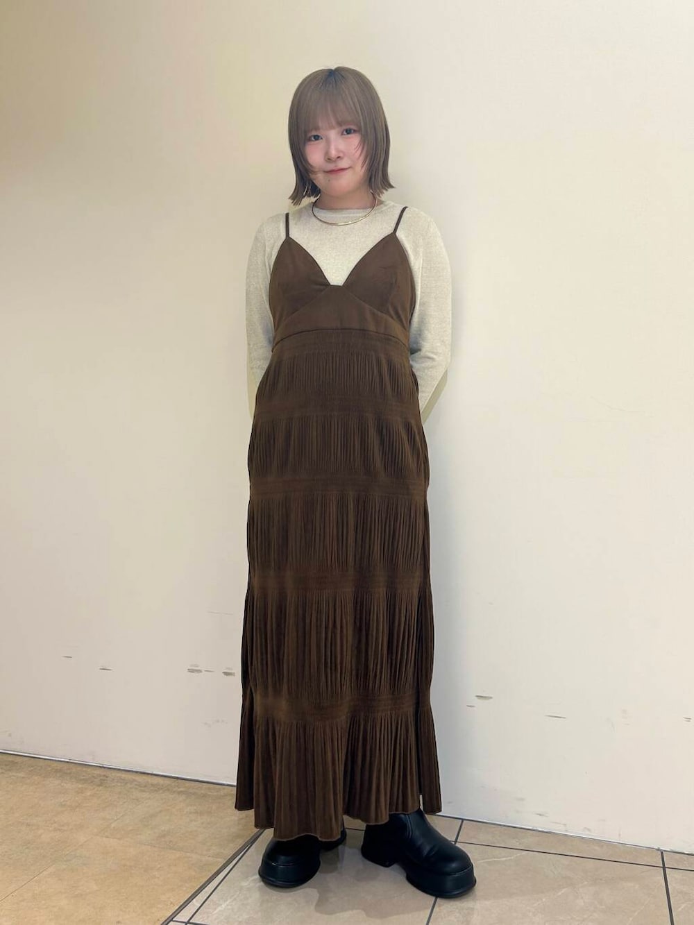 ホワイト系のダウンジャケット/コート、ブラウン系のワンピース、ホワイト系のニット/セーターを着用したレディースの冬コーディネートの5枚目の写真