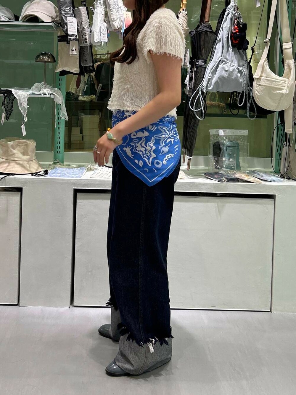 ブルー系のデニムパンツ、イエロー系のニット/セーター、シルバー系のネックレスを着用したレディースの春コーディネートの3枚目の写真