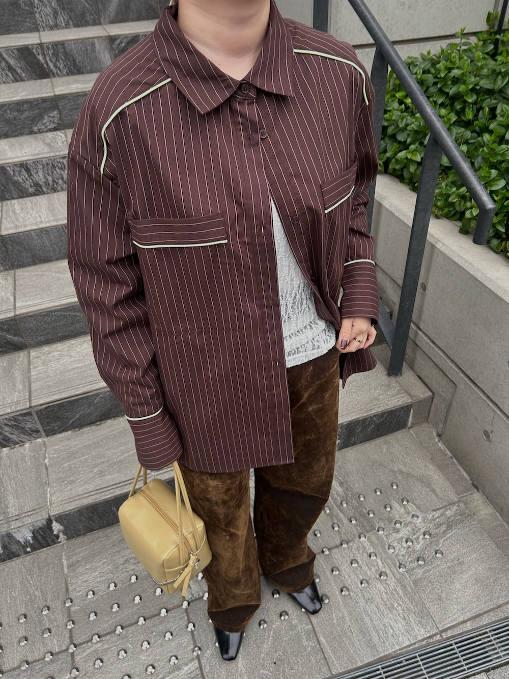 ブラウン系のシャツ/ブラウス、ホワイト系のTシャツ/カットソー、ブラウン系のデニムパンツを着用したレディースの春コーディネートの6枚目の写真