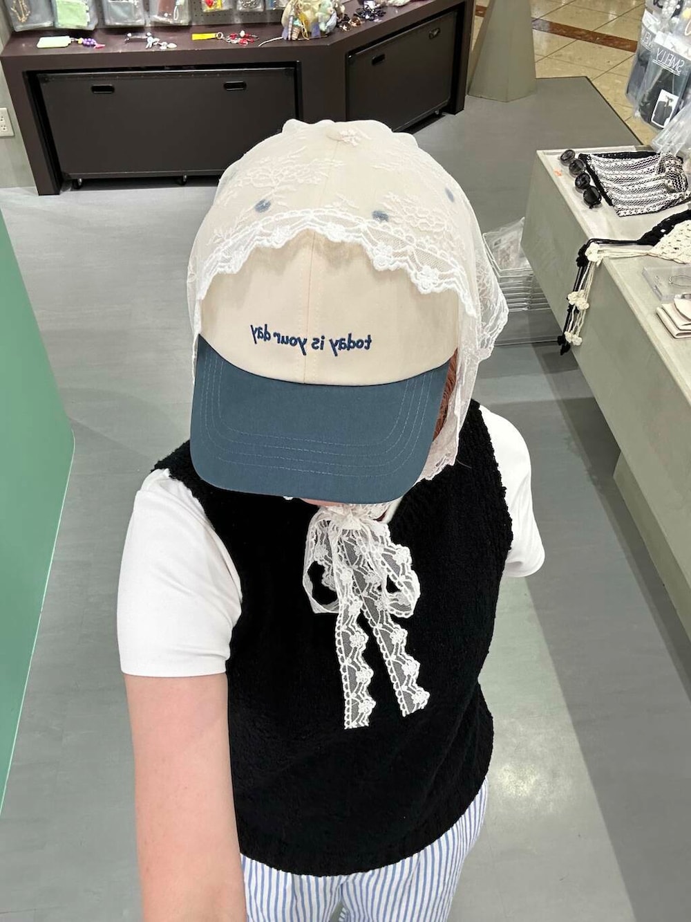 ブラック系のニット/セーター、シルバー系のブレスレット、ホワイト系のヘアゴムを着用したレディースの夏コーディネートの2枚目の写真