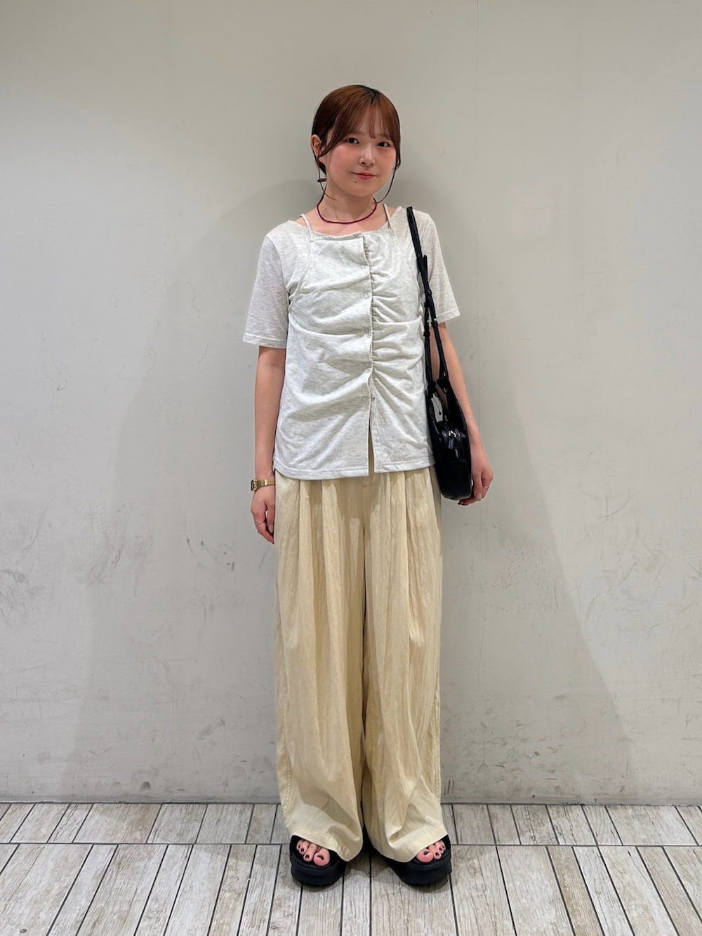 ブラック系のショルダーバッグ、イエロー系のその他パンツ、ベージュ系のTシャツ/カットソーを着用したレディースの夏コーディネートの2枚目の写真