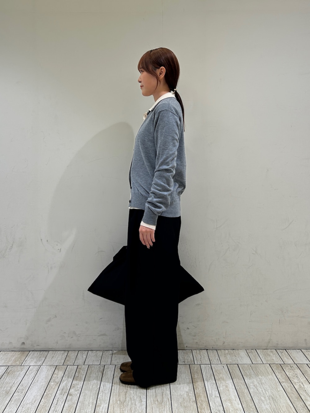グレー系のカーディガン/ボレロ、ホワイト系のカーディガン/ボレロ、ブラック系のハンドバッグを着用したレディースの秋コーディネートの2枚目の写真