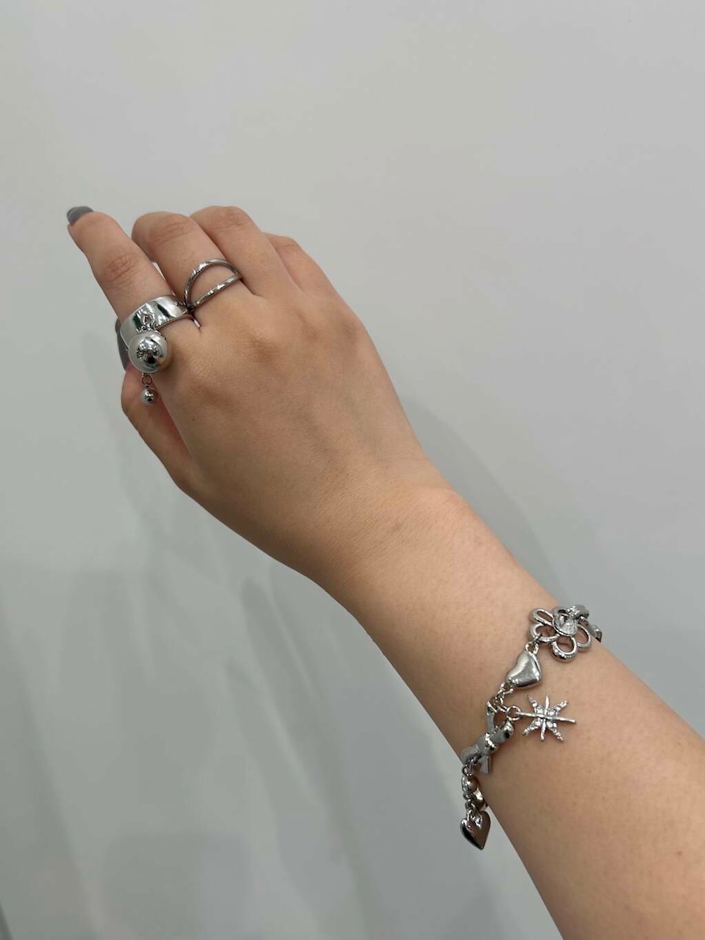 ブラック系のニット/セーター、シルバー系のブレスレット、ホワイト系のヘアゴムを着用したレディースの夏コーディネートの5枚目の写真