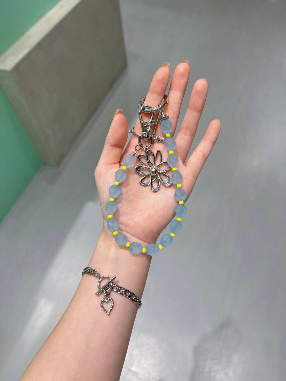 ホワイト系のハンドバッグ、シルバー系のリング、ホワイト系のバレッタ/ヘアクリップを着用したレディースの夏コーディネートの2枚目の写真