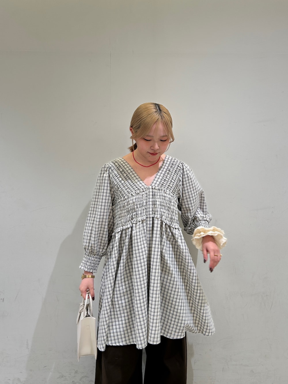 ベージュ系のワンピース、ホワイト系のハンドバッグ、ブラウン系のその他パンツを着用したレディースの春コーディネートの7枚目の写真