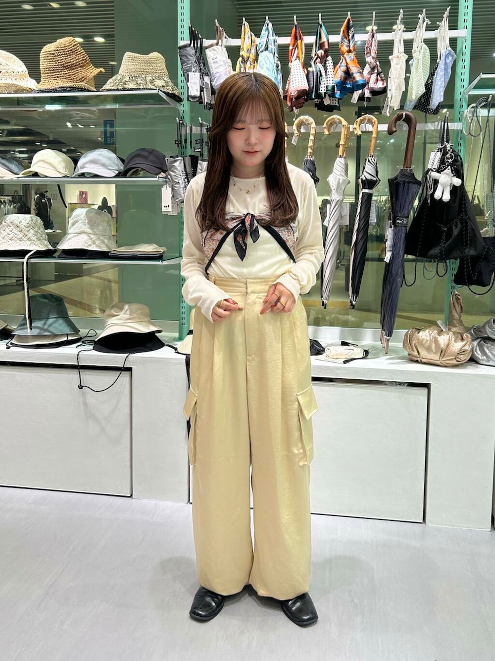 ホワイト系のTシャツ/カットソー、ベージュ系のその他パンツ、ブラック系のバンダナ/スカーフを着用したレディースの春コーディネートの2枚目の写真